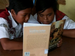 Dua orang siswa sedang serus membaca buku. (Foto. Dok. Dewi Pujiati).