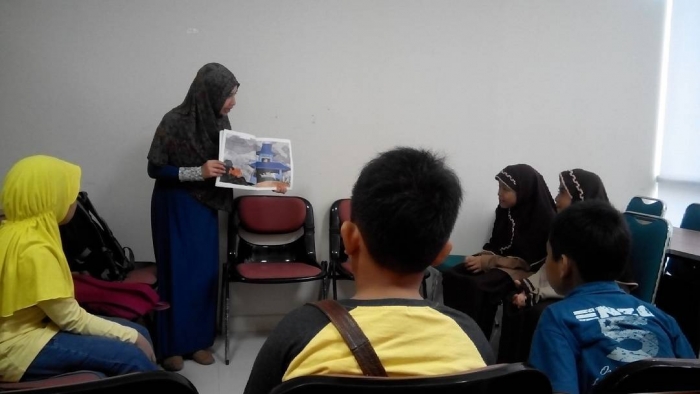 Membacakan sebuah cerita adalah salah satu cara KKI menarik minat anak kepada buku