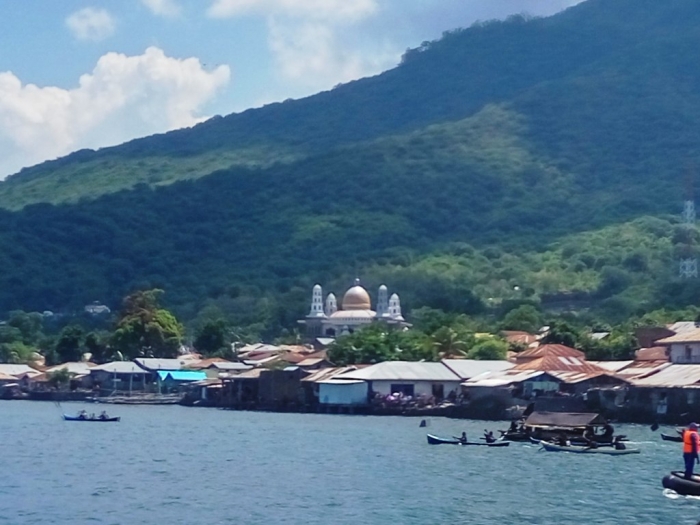 2 Prosesi laut membawa patung Tuan Ana di dalam kapal dengan penutup diatasnya melintasi masjid (Dokumentasi Kompasiana)