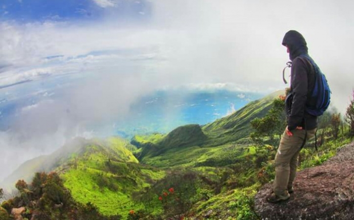 Dhanang pendaki Merbabu mengamati tebing yang curam (foto: dok Dhanang)