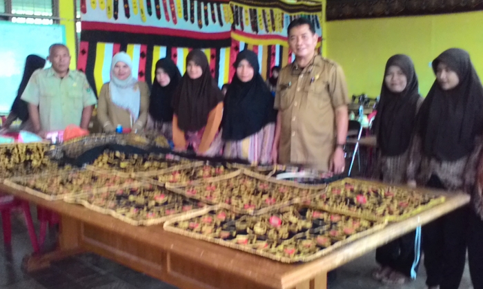 Kepala Panti Andam Dewi, Syahbana, diabadikan dengan anak binaannya yang dilatih menyulam. (DOK. PRIBADI)