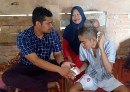 Agus Setiawan saat mengunjungi remaja penderita tumor di kepala. Foto Istimewa.