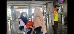 Dua petugas (satpam dan pegawai) di stasiun Kota Bekasi memeriksa STRP calon penumpang (foto : Nur Terbit)