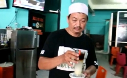 Haji Awaluddin mengantarkan racikan kopi Sianida ke meja langganannya (foto repro Nur Terbit)