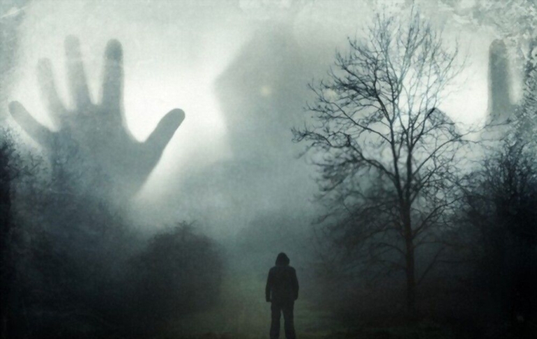 man looking huge ghostly hooded figure | Sumber: Shutterstock