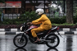 Ilustrasi pengendara saat hujan tanpa mengatupkan kaca helm. Sumber: via Kompas.com/M Lukman Pabriyanto