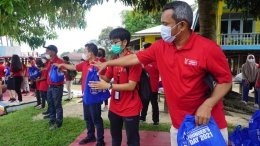 Relawan Founder's Day tengah berbaris menurunkan paket bantuan untuk masyarakat dari Bidak di Desa Kuala Terusan, Pelalawan, Riau/dokpri