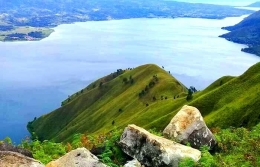 Bukit Sipatungan Sabulan, Sitiotio dengan latar belakang negeri Urat dan Nainggolan di Pulau Samosir (Foto: pariwisatasumut.net)