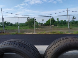 Tire barrier di sisi dalam area sirkuit untuk pengaman benturan dengan latarbelakang rumah penduduk di dekat Sirkuit Mandalika. (Foto: Gapey Sandy) 