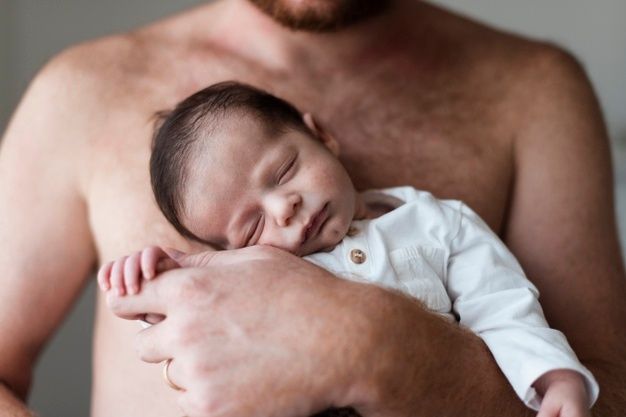 https://image.freepik.com/free-photo/close-up-father-holding-his-sleepy-baby_23-2148354228.jpg