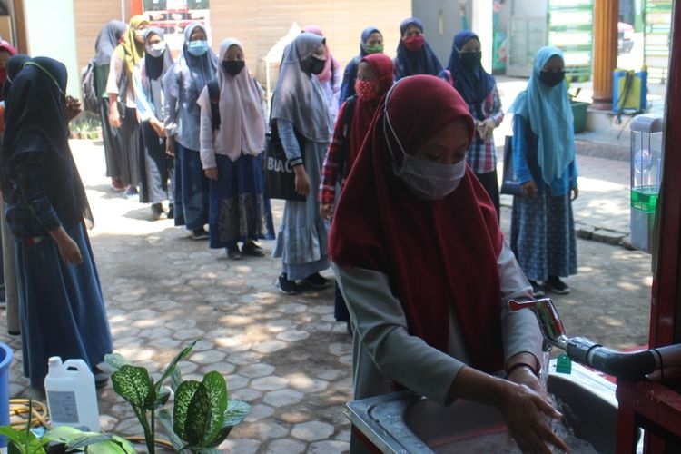 Para santriwati Ponpes Annuriyah Jember wajib cuci tangan dan menggunakan masker sebelum masuk ke ruang kelas (BAGUS SUPRIADI/KOMPAS.COM)