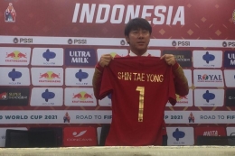 Pelatih baru timnas Indonesia, Shin Tae-yong, mengangkat jersey Merah Putih pada sesi perkenalan di Stadion Pakansari, Kab Bogor, Sabtu (28/12/2019).