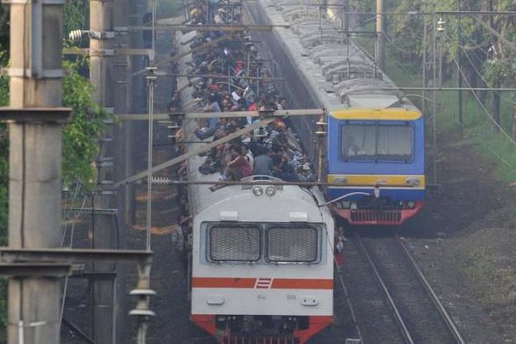 Penumpang memadati atap gerbong kereta rel listrik (KRL) ekonomi Bogor-Jakarta yang melintas di kawasan Tanjung Barat, Pasar Minggu, Jakarta Selatan, Selasa (26/3/2013).(KOMPAS/WAWAN H PRABOWO)