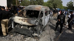 Polisi menjaga tempat kejadian serangan bom bunuh diri di Karachi. Tiga orang China dan seorang warga Pakistan tewas dalam serangan ini. | Sumber: CNN