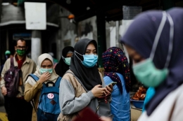 Warga menggunakan masker setelah melewati jembatan penyebrangan orang (JPO) dari stasiun Palmerah di Jakarta, Selasa (3/3/2020). (KOMPAS.com/GARRY LOTULUNG)