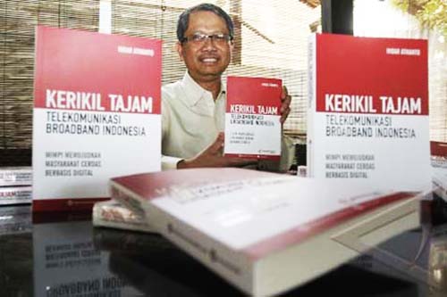 Foto #9 : Indar Atmanto bersama buku karyanya KERIKIL TAJAM Telekomunikasi Broadband Indonesia. (Foto: bisnis.com)