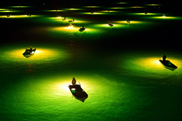 Nelayan menunggu glass eel di sungai Yoshino-Jepang. Agar glass ell tertarik digunakan lampu yang bersinar terang. Ketika glass eel terkumpul dan dekat, nelayan menangkapnya dengan scoop. Foto : thechive.com