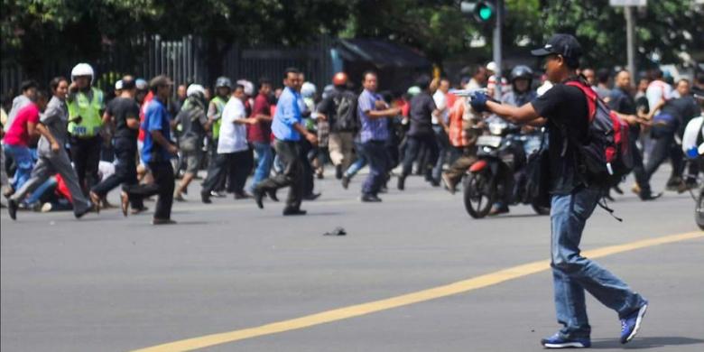 Foto ini dirilis oleh agensi berita China Xinhua, seorang pria tak dikenal dengan senjata, terduga pelaku, terlihat setelah ledakan menghantam kawasan Jalan MH Thamrin, Jakarta Pusat, 14 Januari 2016