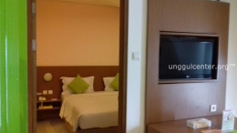 kamar tidur di dalam suite, dengan televisi layar lebar yang bisa berputar