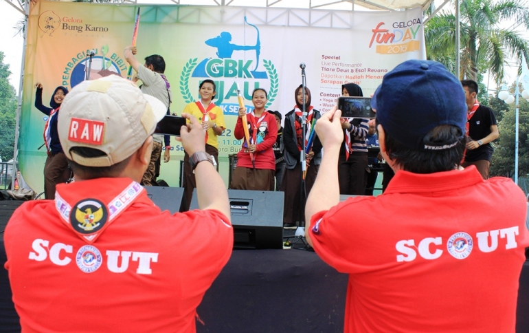 Dua anggota Indonesia Scout Journalist (ISJ) memotret aksi para Pramuka di panggung acara GBK Hijau yang diadakan di Gelora Bung Karno, Senayan, Jakarta, 22 Mei 2016. (foto: Hamas Alrafsan, ISJ)