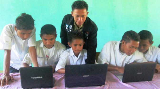 Seorang pendidik memperkenalkan laptop kepada siswa sebagai sarana pembelajaran elektronik. Sumber: http://www.keepo.me