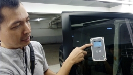Seorang staf V-Kool memperlihatkan I Measure hasil penyinaran dari mobil yang menggunakan kaca film V-Kool 