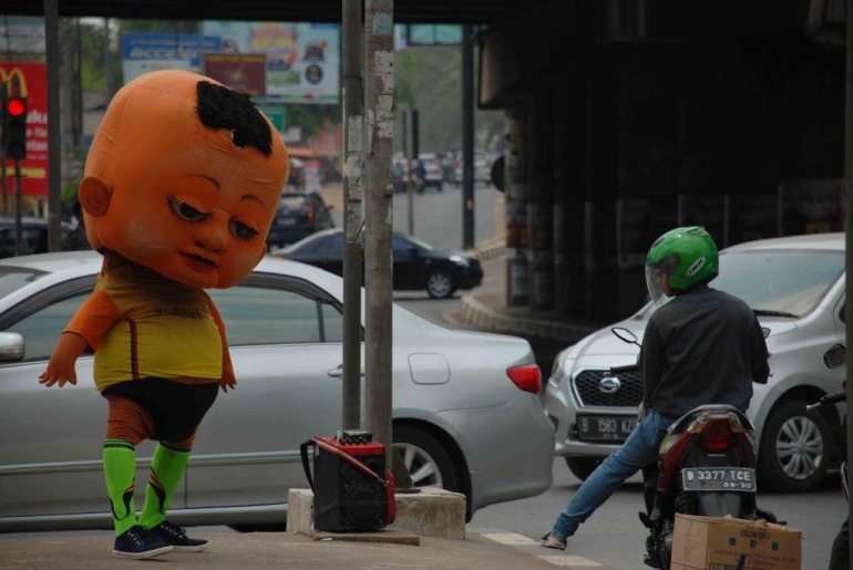 Boneka unik dengan goyangan kepalaya yang khas di pinggir jalan (gobekasi.pojoksatu.id)