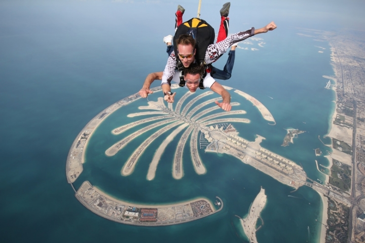 Dua orang penerjun berfoto dari udara dengan latar belakang Palm Jumairah, pulau reklamasi yang legendaris di Dubai (Sumber : ahlanlive.com)