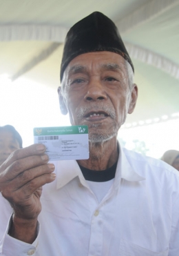 seorang lelaki penerima KIS di Jawa Timur, dengan bergotong royong 