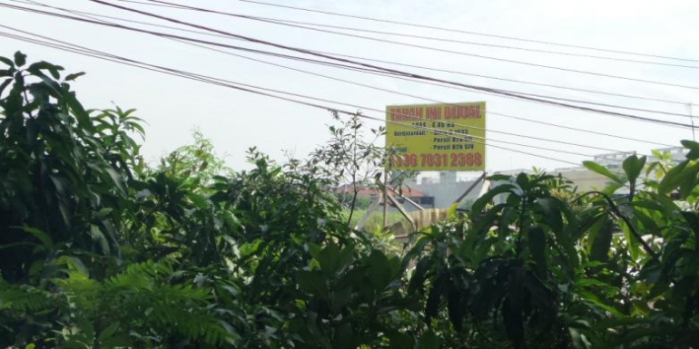 Plang bertuliskan "dijual" di lahan Rusun Cengkareng Barat. (Kompas.com/David Oliver Purba)