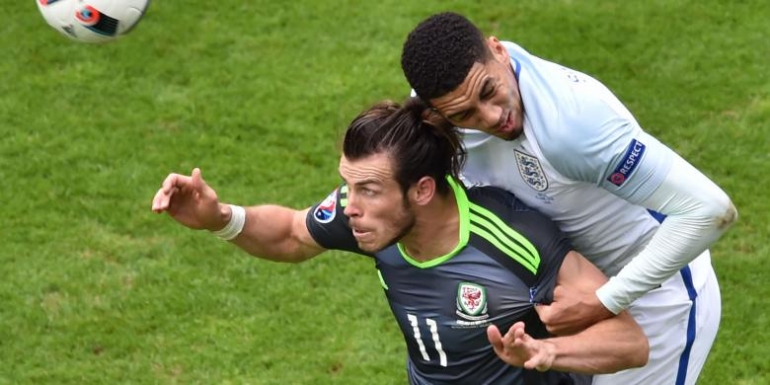 PHILIPPE HUGUEN/AFP Bek Inggris, Chris Smalling (kanan), berduel dengan penyerang Wales, Gareth Bale