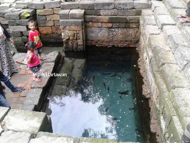Kolam Candi Penataran, penuh ikan dan uang logam. Dinding kolam berderet relief cerita.