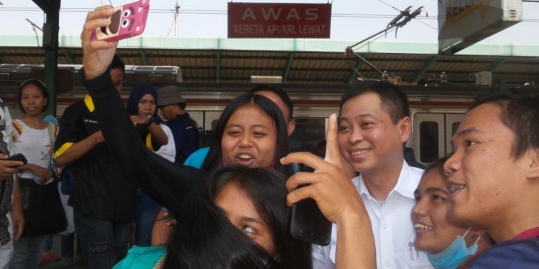 Menteri Perhubungan Ignasius Jonan saat berselfie dengan sejumlah penumpang KRL di sela-sela kunjungannya ke Stasiun Manggarai, Kamis (24/9/2015). | Kompas.com/Alsadad Rudi