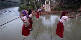 Jembatan gantung di Ciliman, anak-anak SD perempuan ini juga harus bergelantungan dan meniti tali atau labrang untuk ke sekolah mereka. Ini infrastruktur apa ya? Infrastruktur jembatan layang tali atau layang labrang barangkali? (Pic Source: Kaskus)