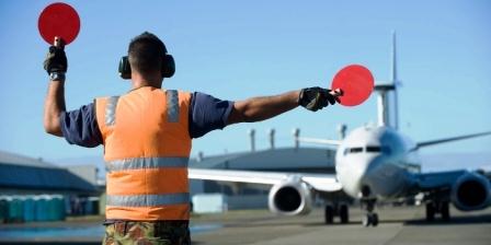 Marshaller sedang memandu pilot untuk parkir pesawat (gbr dr hva.nl)