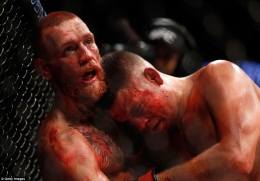 McGregor pinned to the side of the cage by the larger Diaz. Photo by Getty Image
