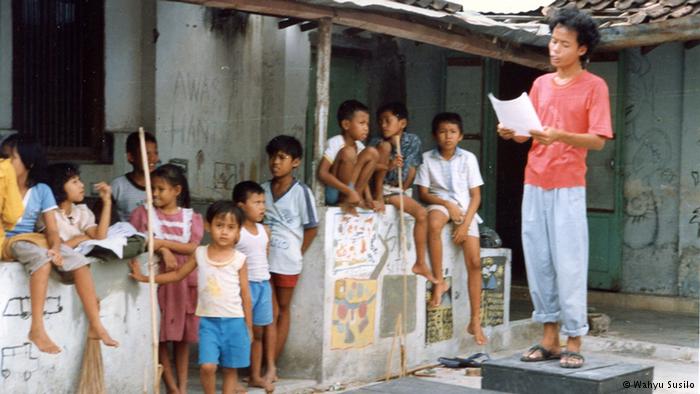 Widji Thukul membacakan puisi di depan anak-anak di perkampungan, medio 1990an. | sumber: http://blogmasjok.wordpress.com