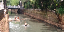 Dua bocah Haikal dan Aldi saat bermain dan berenang di aliran Kali Mampang, Jakarta Selatan, Jumat (6/5/2016). (Kompas.com/Robertus Belarminus)