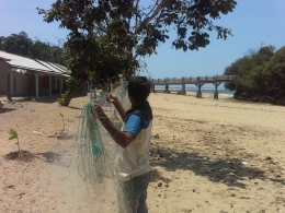 Pak Riamun sedang memperbaiki jaring di depan gubuknya yang berada di ujung tepi pantai Balekambang/Dok. pribadi