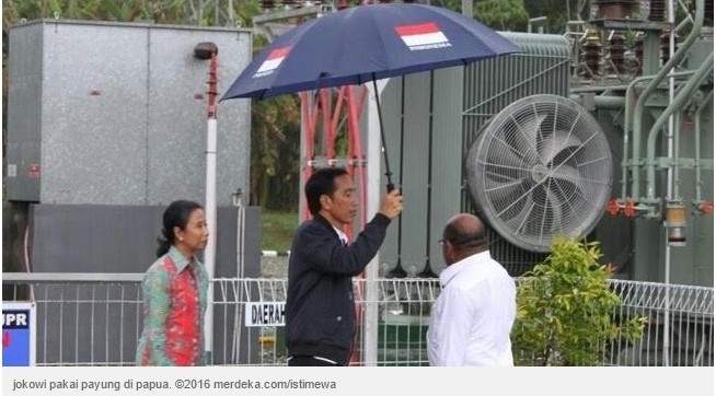 Foto Presiden Jokowi memayungi Gubernur Papua Barat Lukas Enembe yang menjadi viral (Merdeka.com)