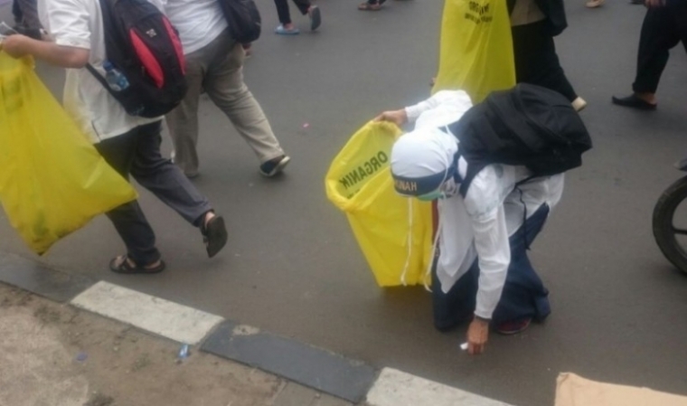foto : para demonstran memungut sampah sambil bubar dari mesjid Istiqlal (republika.co.id)