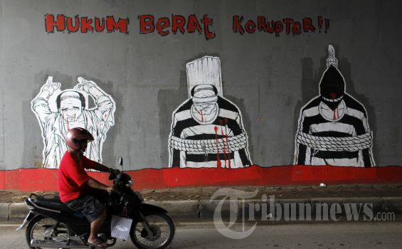 Sebuah lukisan di tembok jalan yang menuntut hukuman berat untuk para koruptor. Tribunnews.com