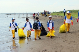 Anak-anak SD bersih pantai di acara HUT Pertamina. (Foto GANENDRA)