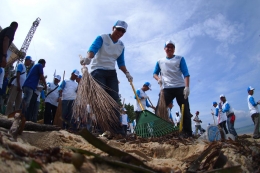 Direktur Keuangan dan Strategi Perusahaan PT Pertamina (Persero) Arif Budiman (kanan) saat bersih-bersih di Pantai Kampung Bugis.
