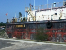Salah satu bagian luar kapal yang tidak dicat ulang, dibiarkan terlihat kusam agar tetap menunjukkan keaslian warna cat kapal tersebut saat diterjang tsunami (foto dok pri).