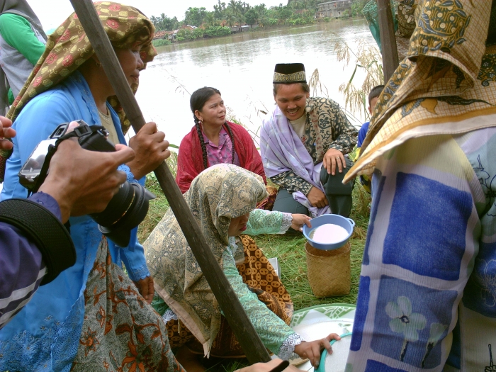 Warga Desa Penyengat Olak menyaring tepung hasil tumbukan