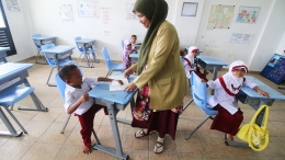 Guru memberikan arahan memasuki tahun ajaran baru sekolah kepada 11 murid kelas I di SD Negeri Lampageu, Kecamatan Peukan Bada, Kabupaten Aceh Besar, Provinsi Aceh, Senin (27/7). (KOMPAS/ADRIAN FAJRIANSYAH)