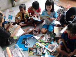 Semangat dan keceriaan anak-anak membaca buku tentang lingkungan dan satwa. Foto dok. Yayasan Palung