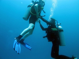 Ket foto : seorang instruktur sedang mendampingi siswa-nya saat pertama kali ke laut (open water exam). Koleksi pribadi: siswa calon diver dengan instruktur