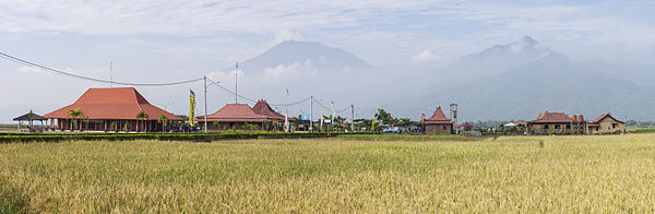 Pemandangan panorama Kampoeng Rawa dengan (dari kiri ke kanan) pusat kerajinan, balai, pendopo, tempat istirahat untuk supir bus, musholla, dan restoran. Gunung Merbabu dan Gunung Telomoyo berada di latar belakang (Sumber: https://id.wikipedia.org/wiki/Kampoeng_Rawa)